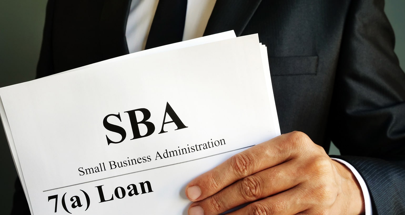 SBA loan form held by a businessman.