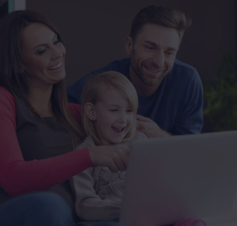 A high-net-worth family looking at a laptop on their home network