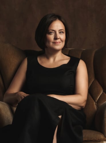 A businesswoman seated in a leather armchair.