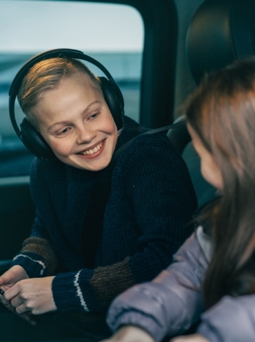 Kids in a car using digital devices.