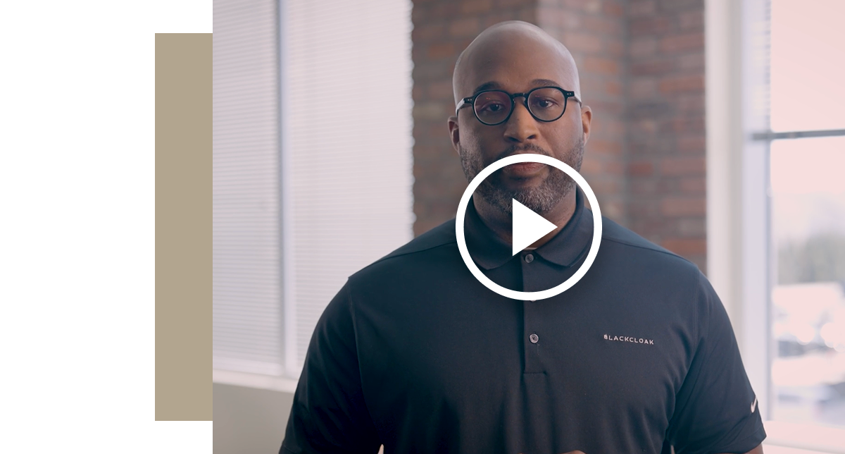 A man wearing glasses and a black polo shirt with a small BlackCloak logo, looking directly at the camera. A large white play icon is centered over his chest. The video is about Data broker removal and data minimization strategies.