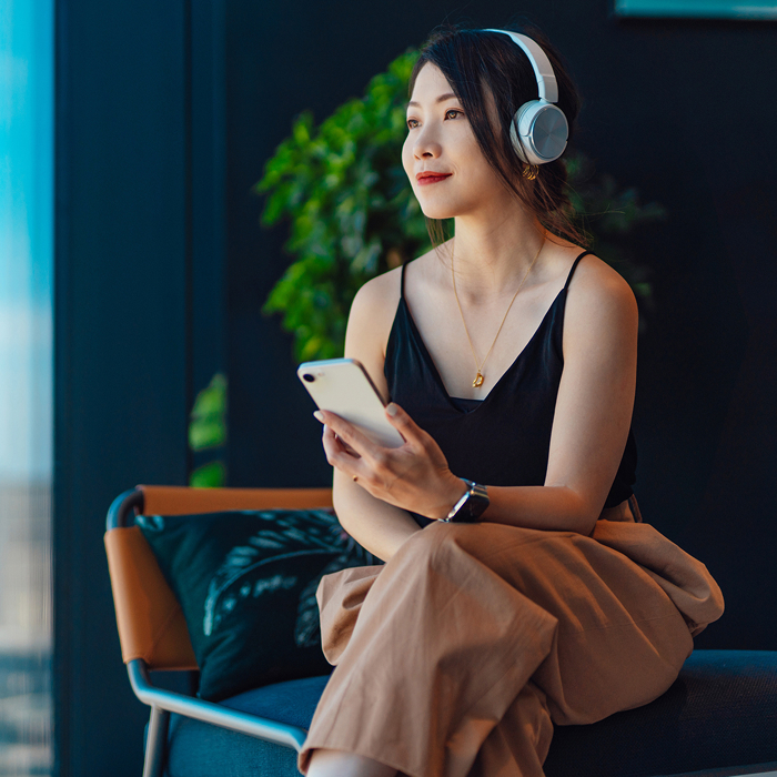 Girl wearing headphones and holding a phone