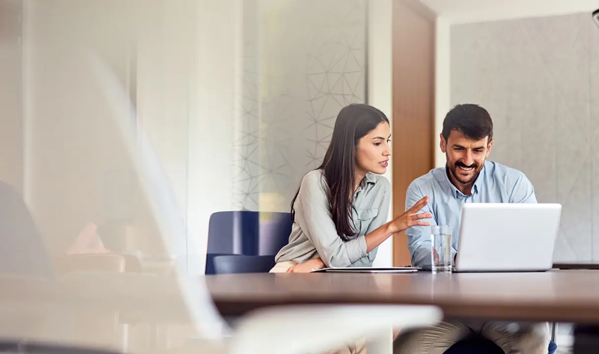 Man and woman talking with a laptop