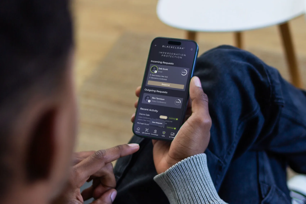 Person holding a phone showing BlackCloak Impersonation Protection requests